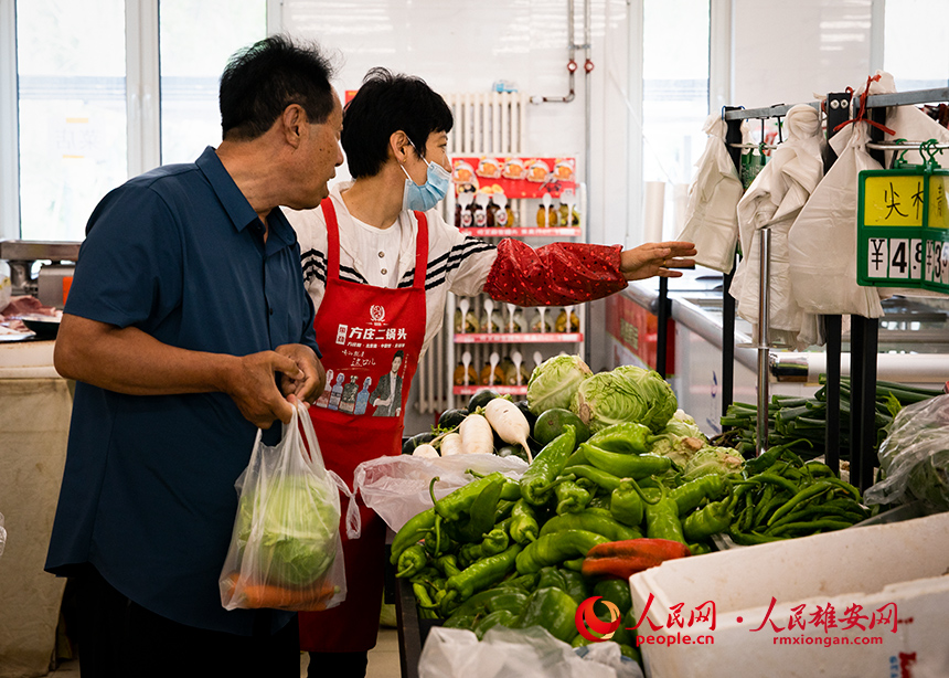 菜店內(nèi)，工作人員正在為顧客提供幫助。出門(mén)就是菜店，吃飯不發(fā)愁，成為容東片區(qū)居民的日常。人民網(wǎng)?宋燁文攝