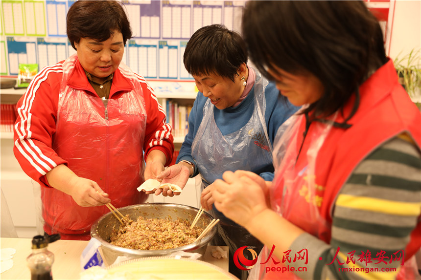 圖為容西片區(qū)飛泉社區(qū)組織回遷居民包餃子。人民網(wǎng) 楊華龍攝