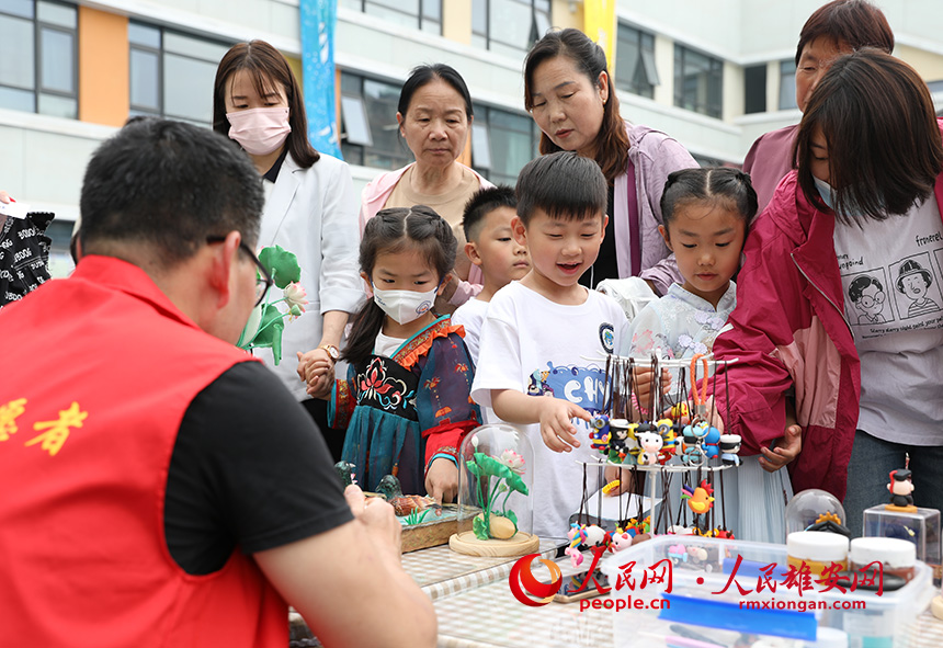 5月31日，雄安容和樂安幼兒園舉辦傳統(tǒng)文化游園活動?；顒友埩诵郯伯?dāng)?shù)胤沁z文化傳承人走進(jìn)幼兒園，與孩子和家長交流互動。通過現(xiàn)場接觸非遺項(xiàng)目，讓孩子們零距離認(rèn)識非遺、熟悉非遺，感受非遺之美。人民網(wǎng) 李兆民攝