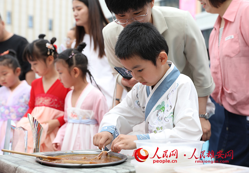 5月31日，雄安容和樂安幼兒園舉辦傳統(tǒng)文化游園活動(dòng)?；顒?dòng)邀請(qǐng)了雄安當(dāng)?shù)胤沁z文化傳承人走進(jìn)幼兒園，與孩子和家長(zhǎng)交流互動(dòng)。通過現(xiàn)場(chǎng)接觸非遺項(xiàng)目，讓孩子們零距離認(rèn)識(shí)非遺、熟悉非遺，感受非遺之美。人民網(wǎng) 李兆民攝