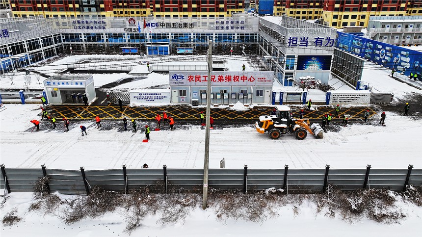 雄東安置房B單元項目組織建設(shè)者開展清雪除冰工作。中國五冶供圖